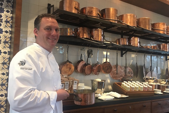 Mike Wehrle in front of cooking pots once used by chef Auguste Escoffier, 1846-1935.