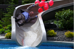 Area General Manager Patrick Shimon made the inaugural slide into the pool fully dressed in what he called “his finest suit, of course. It is the only one suited for the finest pool.”