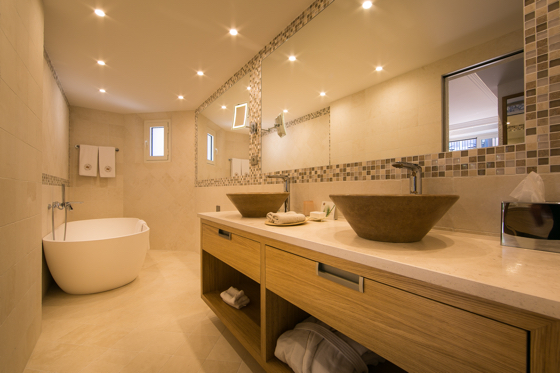 All the bathrooms are modern featuring large bathtubs, sable-colored stone walls and floors, and modern friezes coordinated with the colors of the suites.