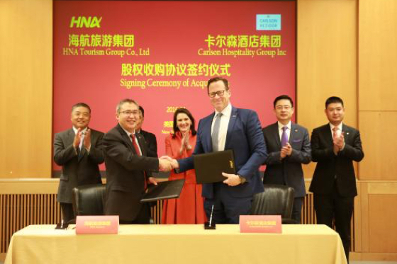 Bai Haibo, chairman and CEO, HNA Hospitality Group, and David Berg, CEO, Carlson Hospitality Group, shake hands over the new deal. Witness leaders (l. to r.): Chen Wenli, vice chairman, HNA Group; Wang Jian, chairman, HNA Group*; Diana Nelson, chair, Carlson; Cheng Feng, chairman of board member, HNA Group*; Tan Xiangdong, CEO, HNA Group; Li Tie, CEO, HNA Tourism Group. *not visible