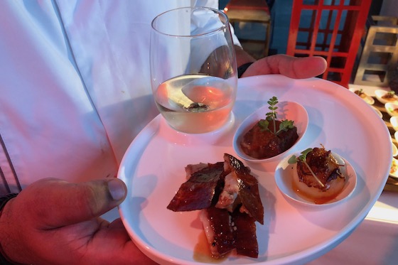 Chef Mander Madav holds a glass inserted into the slot of a plate at a Singapore-themed buffet at the Conrad Centennial Singapore. 