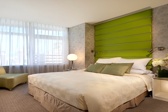A green accent wall adds color to the guestroom.