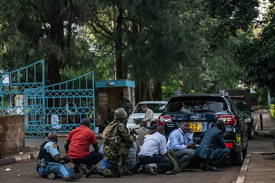 People take cover after hearing gunfire coming from the Dusit Hotel complex after being rescued on January 15 in Nairobi, Kenya. (Getty Images) 