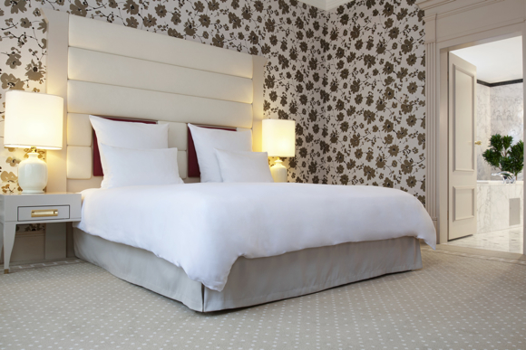 The Diplomatic Suite’s master bedroom uses a predominance of white and floral wall coverings to achieve a feminine feel.